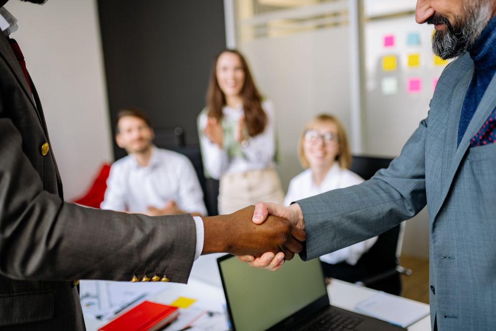 Handshake while the team applauds in a meeting