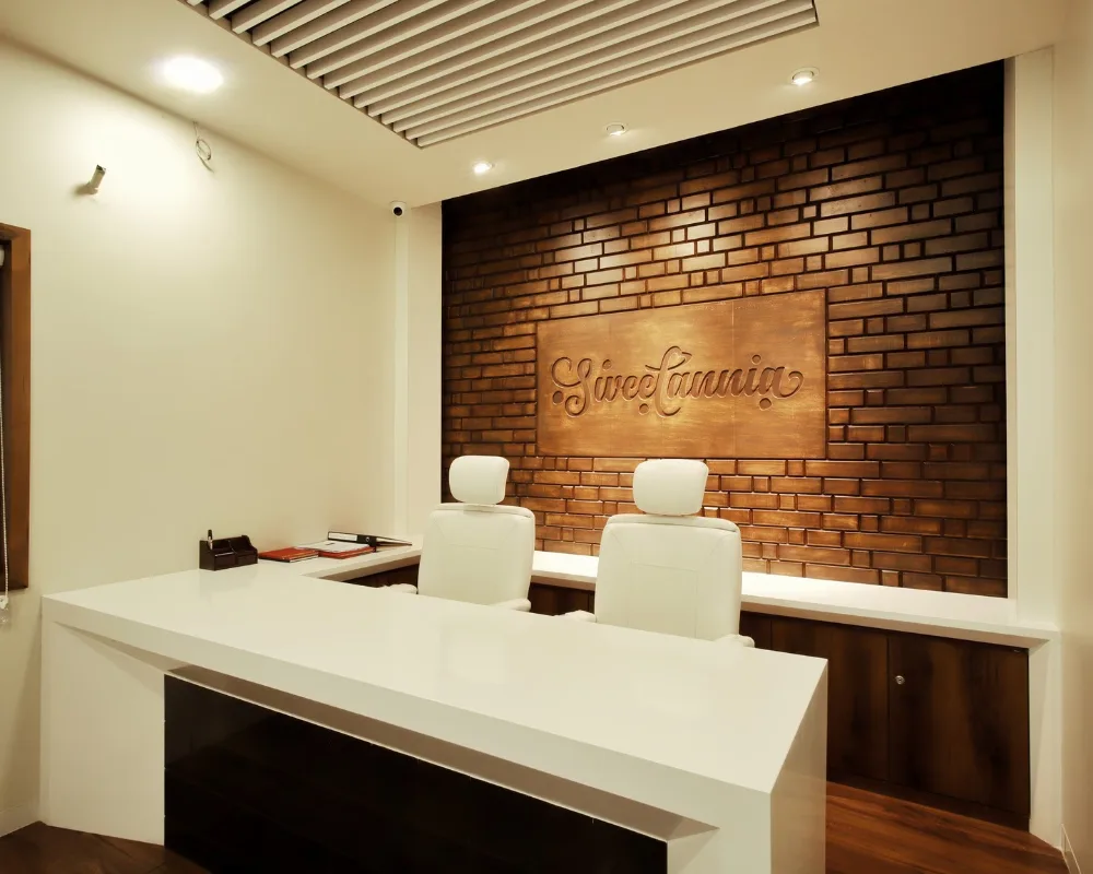Sweetannia office reception in Rajkot with the Sweetannia logo on a brick wall